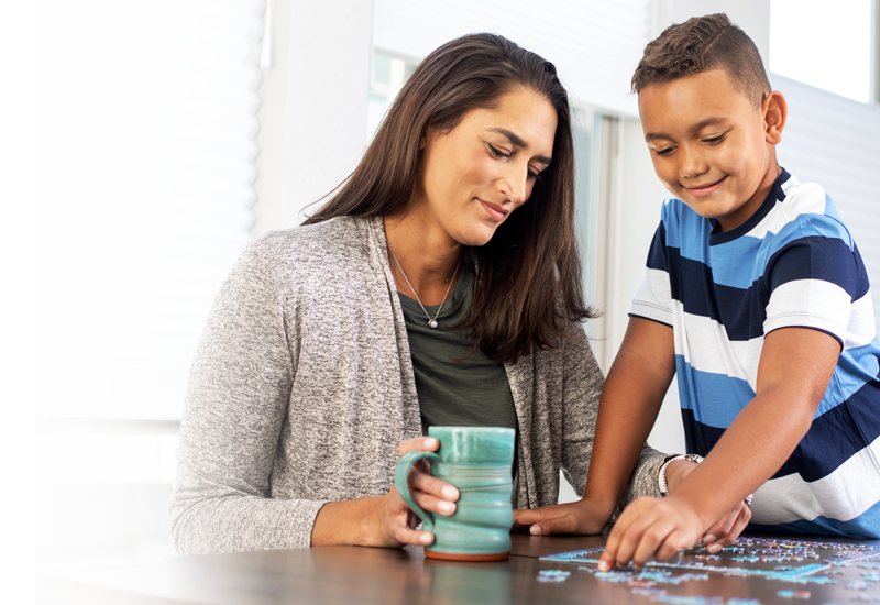 Promotional Image of a woman solving a puzzle with a child